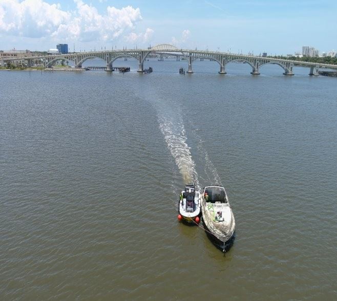Picture of derelict boat being towed by another boat
